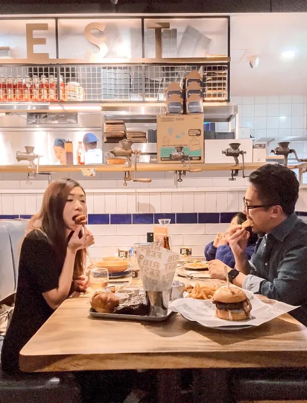 Jeannie and a friend sharing burgers at a café counter